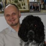 Michael Freund, Lehrer und Biologe aus Bayern, sitzt mit seinem schwarzen Hund auf einem Porträtfoto